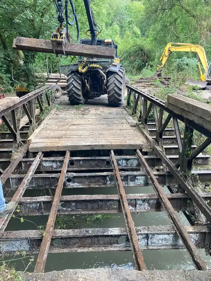 Forwarder carrying timber across a bridge during repairs at Great Elm